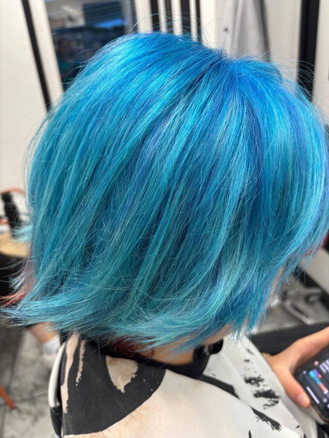 Chin-length graduated bob coloured in vivid turquoise and sapphire blue, with the colour shifting tone through the layers.